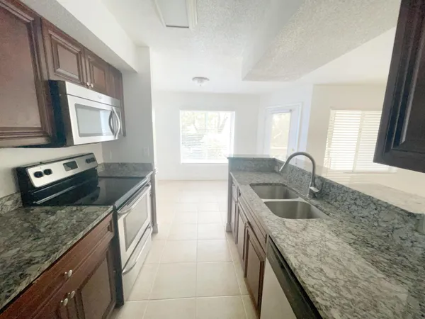 a kitchen with stainless steel appliances granite countertop a sink stove and microwave