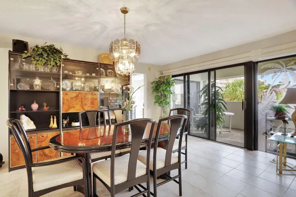 a view of a dining room and livingroom with furniture wooden floor a chandelier