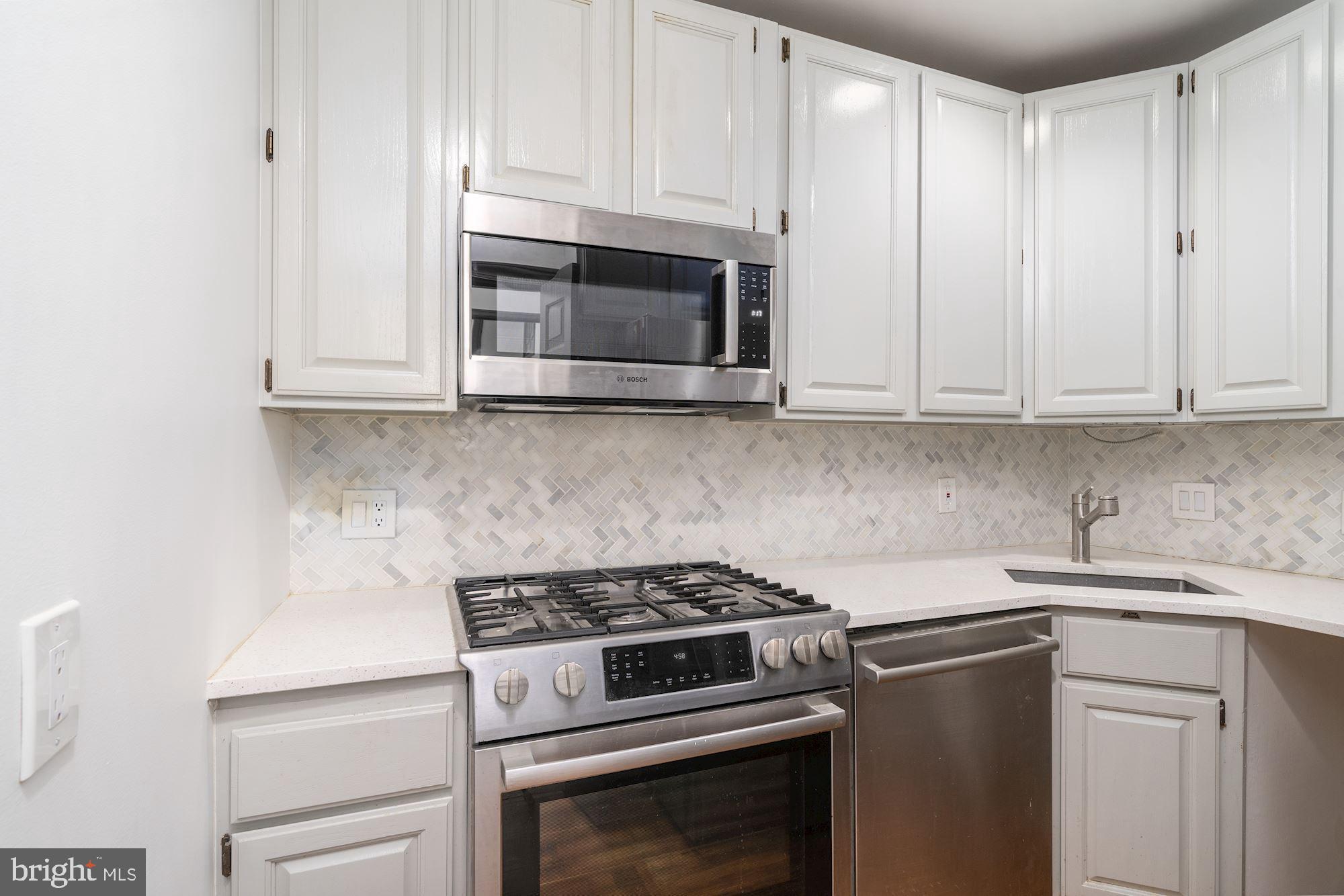3267 N Street Northwest, Unit 2 Washington, DC 20007 - Photo 11 of 21 a kitchen with granite countertop white cabinets and stainless steel appliances