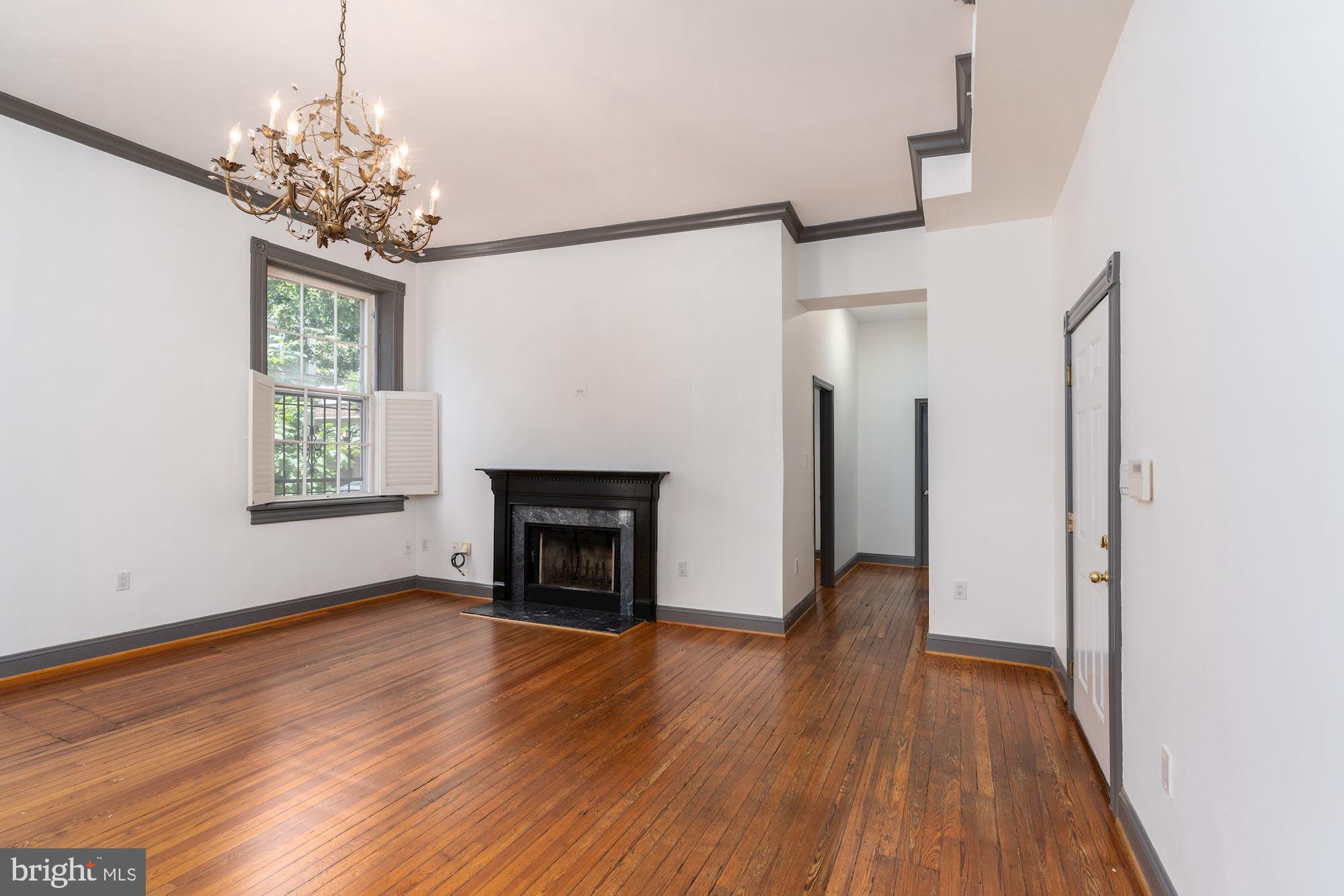 3267 N Street Northwest, Unit 2 Washington, DC 20007 - Photo 7 of 21 a view of an empty room with wooden floor fireplace and a window