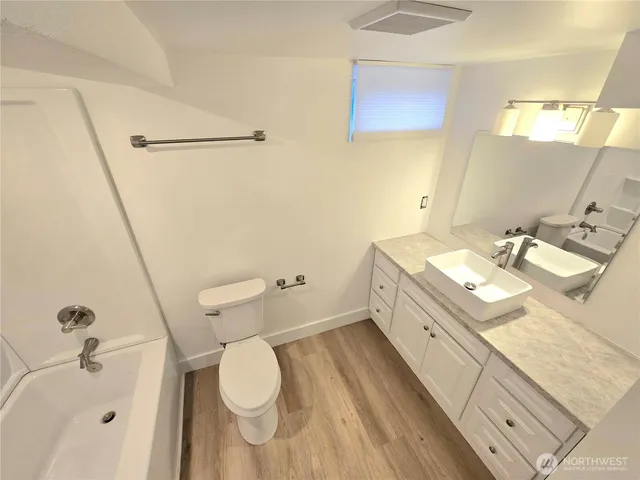 a bathroom with a granite countertop sink a toilet and a mirror