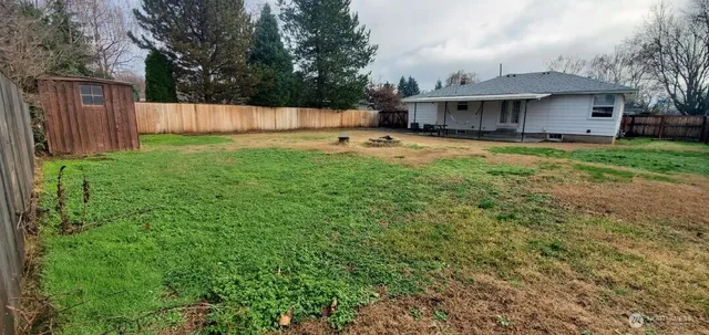 a view of a backyard with wooden fence