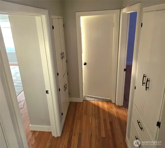 a view of a hallway with wooden floor and staircase
