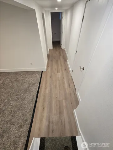 a view of a hallway with wooden floor