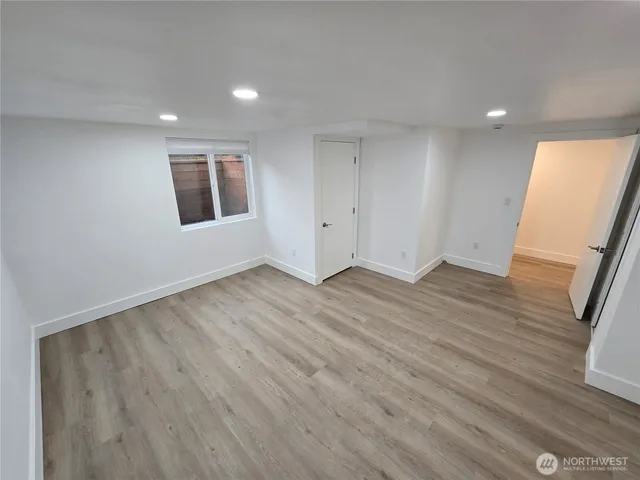 a view of a big room with wooden floor and entrance