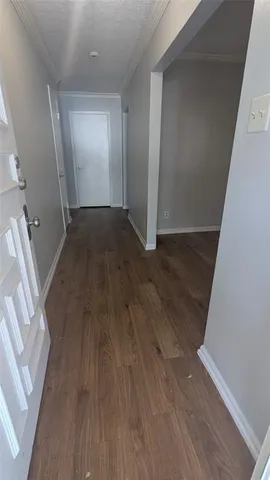 an empty room with wooden floor and entrance