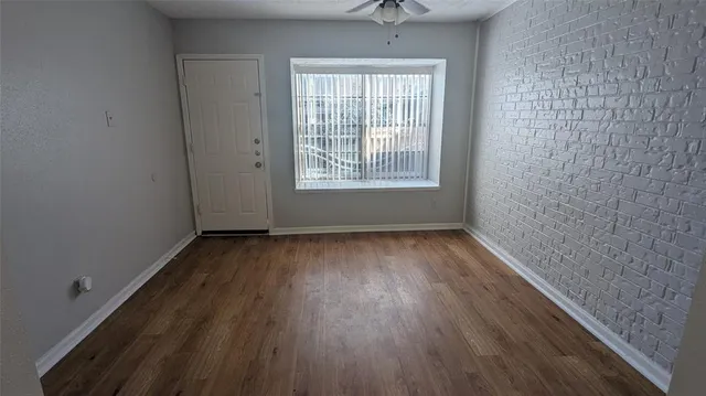 a view of a room with wooden floor and window