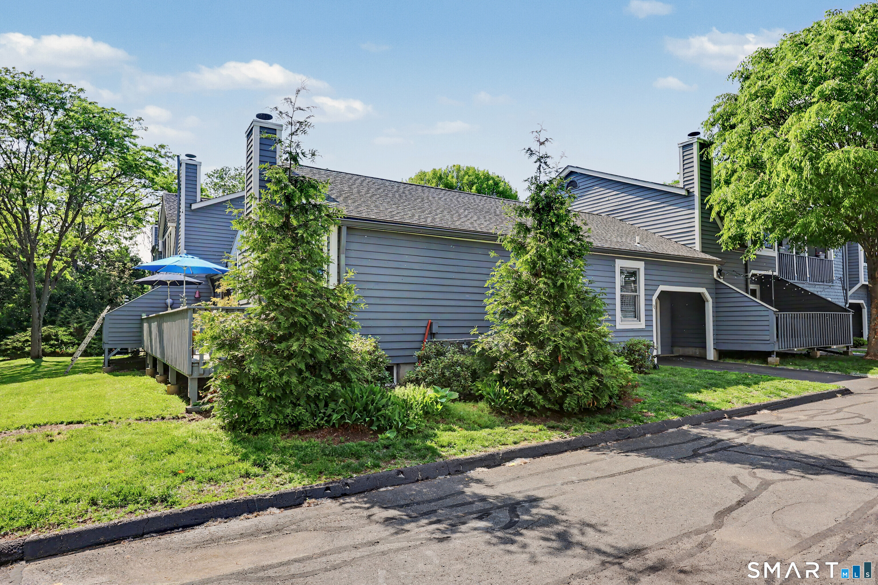 70 Fawn Ridge Lane, Unit 70 Norwalk, CT 06851 - Photo 27 of 36 a plant is in front of a house next to a yard
