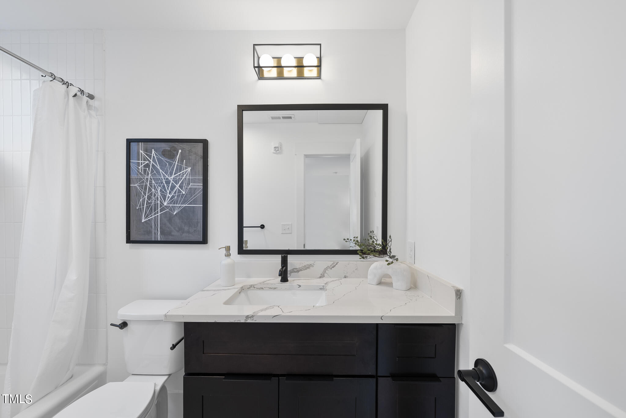 2 Seawell Avenue, Unit 105 Raleigh, NC 27601 - Photo 15 of 40 a bathroom with a sink and a mirror