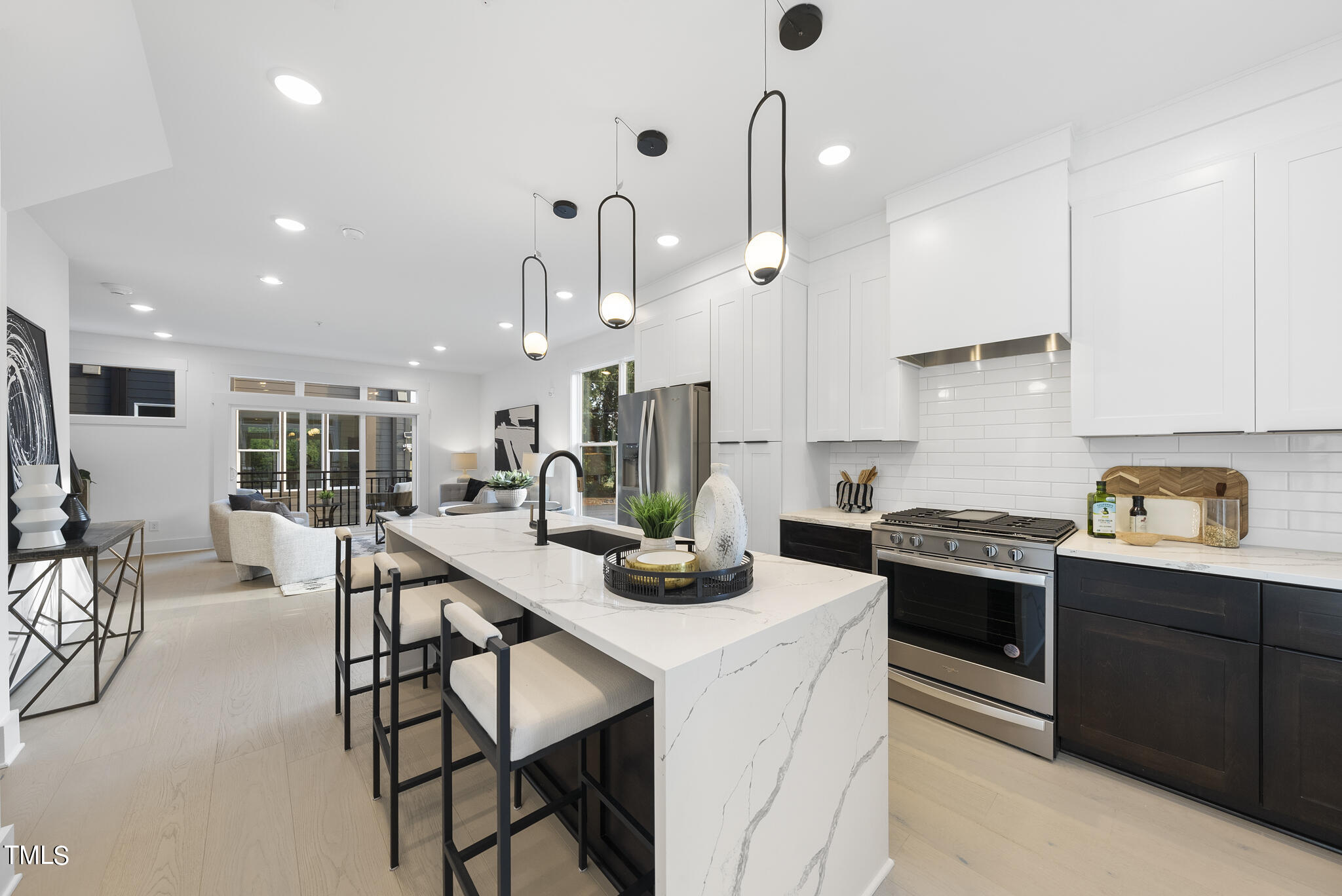 2 Seawell Avenue, Unit 105 Raleigh, NC 27601 - Photo 6 of 40 a kitchen with stainless steel appliances kitchen island granite countertop a stove a sink a refrigerator and white cabinets with wooden floor