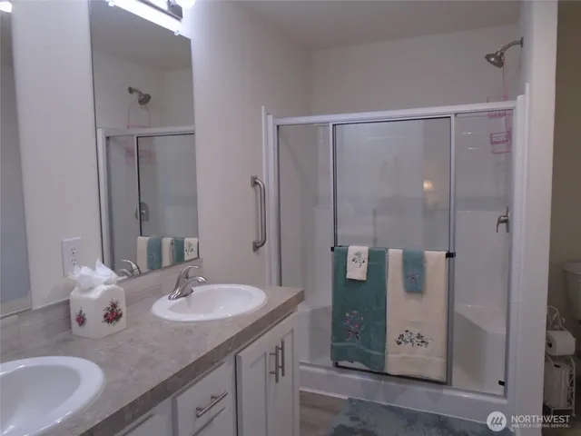 a bathroom with a granite countertop sink shower and mirror