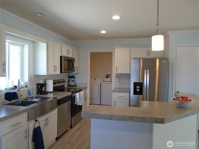 a kitchen with refrigerator a sink and a couch
