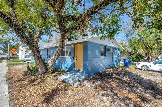 a view of a house with backyard and tree