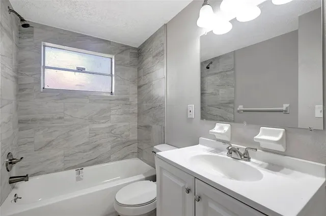 a bathroom with a bathtub a sink a toilet and a mirror