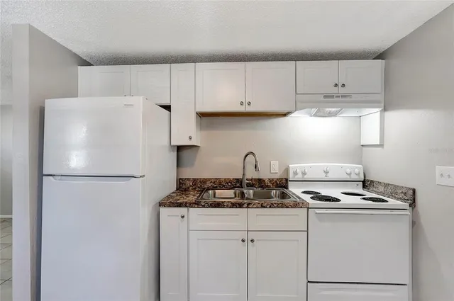 a white refrigerator freezer sitting inside of a kitchen