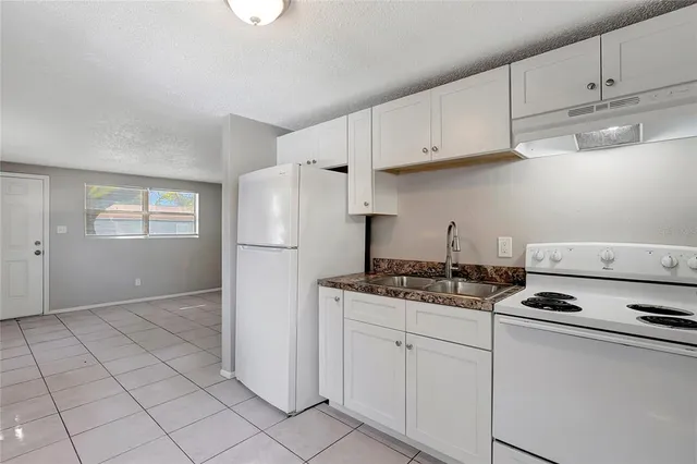 a kitchen with white cabinets and appliances