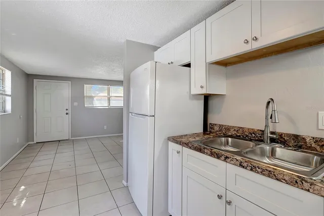 a kitchen with granite countertop a sink a stove and cabinets