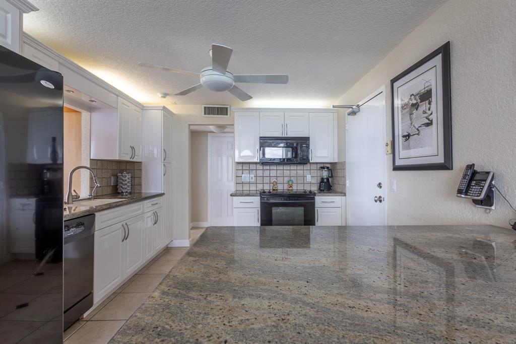 2000 South Ocean Boulevard, Unit 10E Lauderdale-by-the-Sea, FL 33062 - Photo 20 of 86 a large kitchen with cabinets a sink and stainless steel appliances