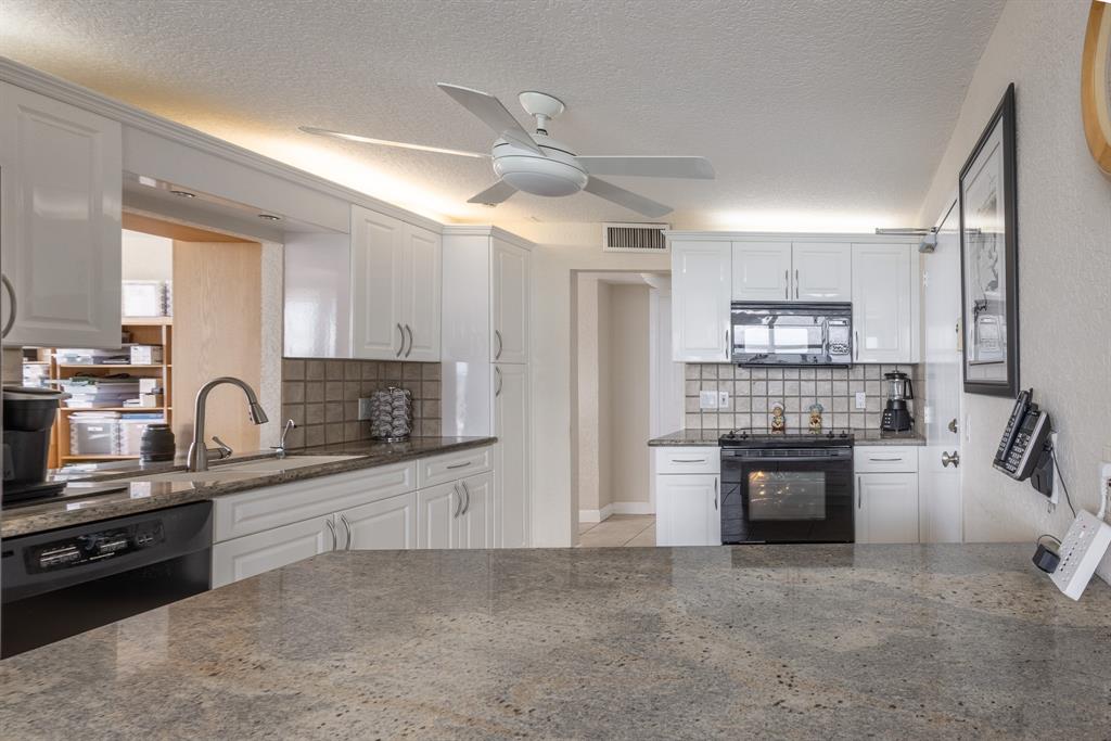 2000 South Ocean Boulevard, Unit 10E Lauderdale-by-the-Sea, FL 33062 - Photo 22 of 86 a kitchen with stainless steel appliances granite countertop a sink refrigerator and cabinets