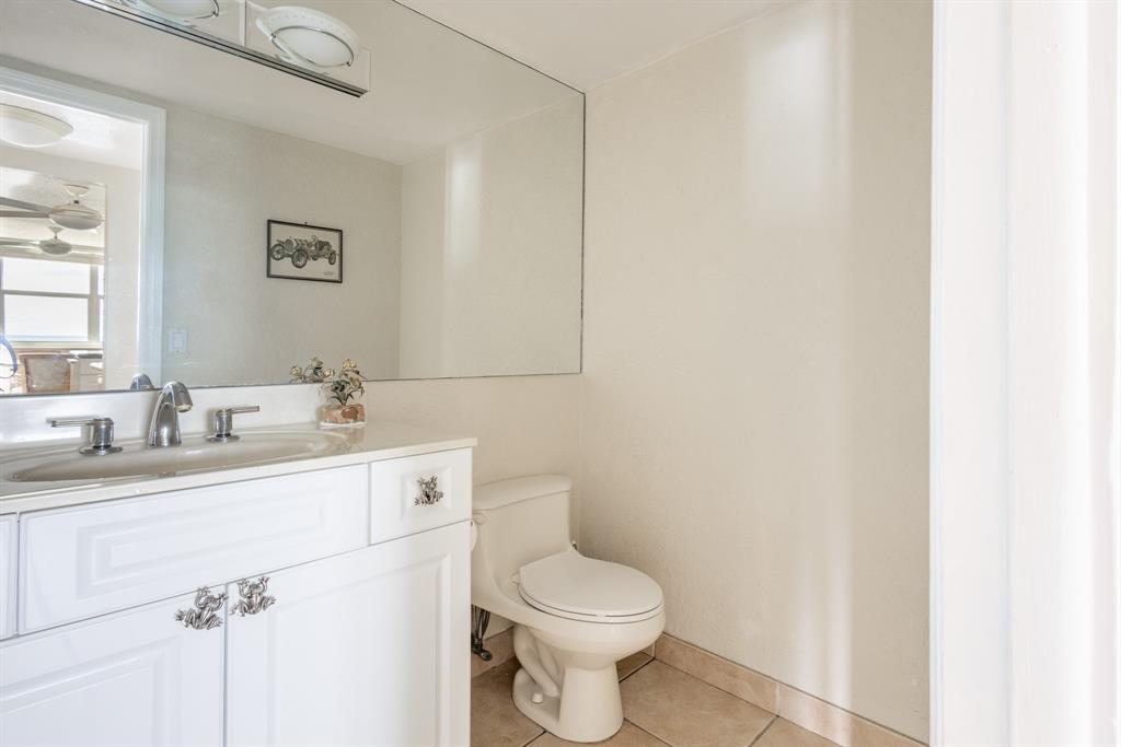 2000 South Ocean Boulevard, Unit 10E Lauderdale-by-the-Sea, FL 33062 - Photo 27 of 86 a bathroom with a toilet sink vanity and mirror