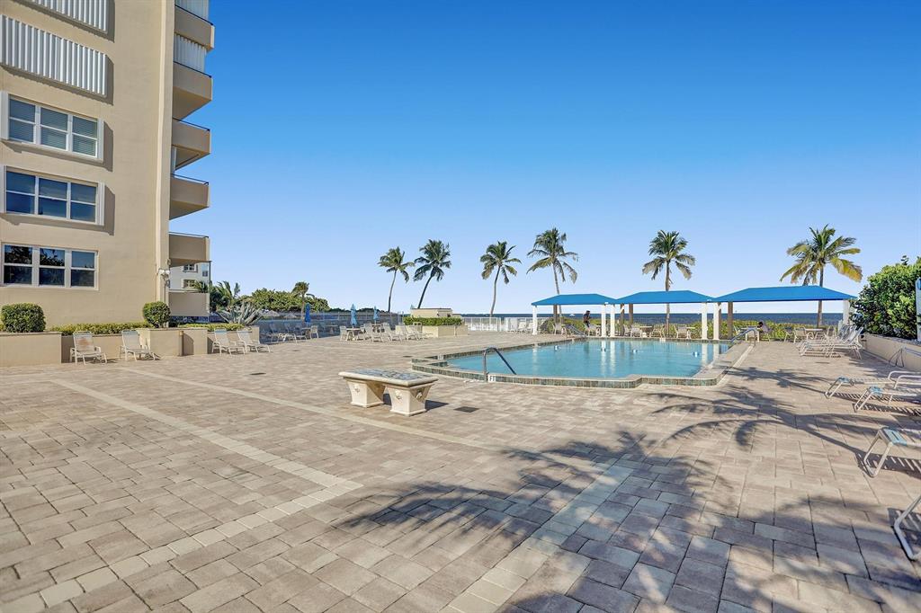 2000 South Ocean Boulevard, Unit 10E Lauderdale-by-the-Sea, FL 33062 - Photo 52 of 86 a view of a swimming pool with a yard