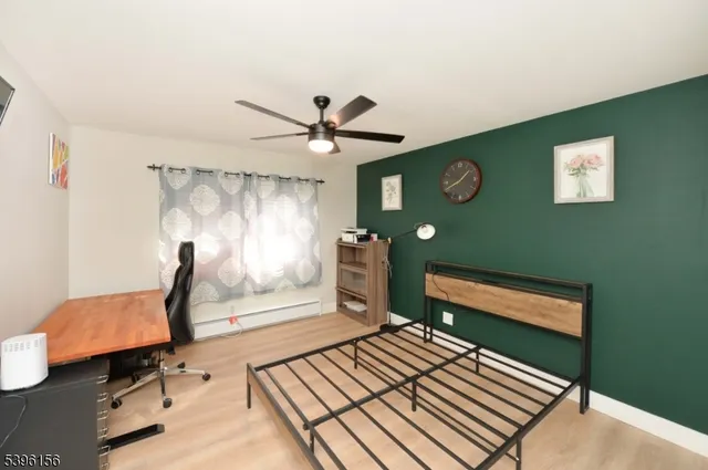 a living room with furniture a clock on wall and a window