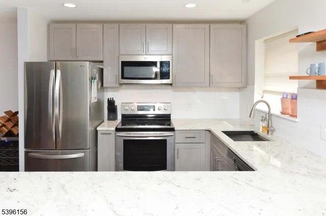 a kitchen with a sink a microwave a refrigerator and cabinets