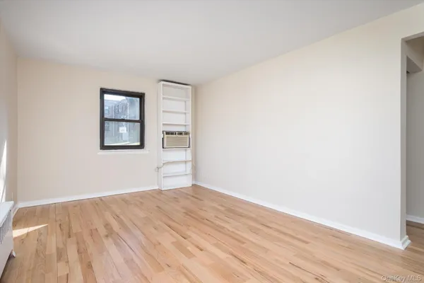a view of empty room with wooden floor