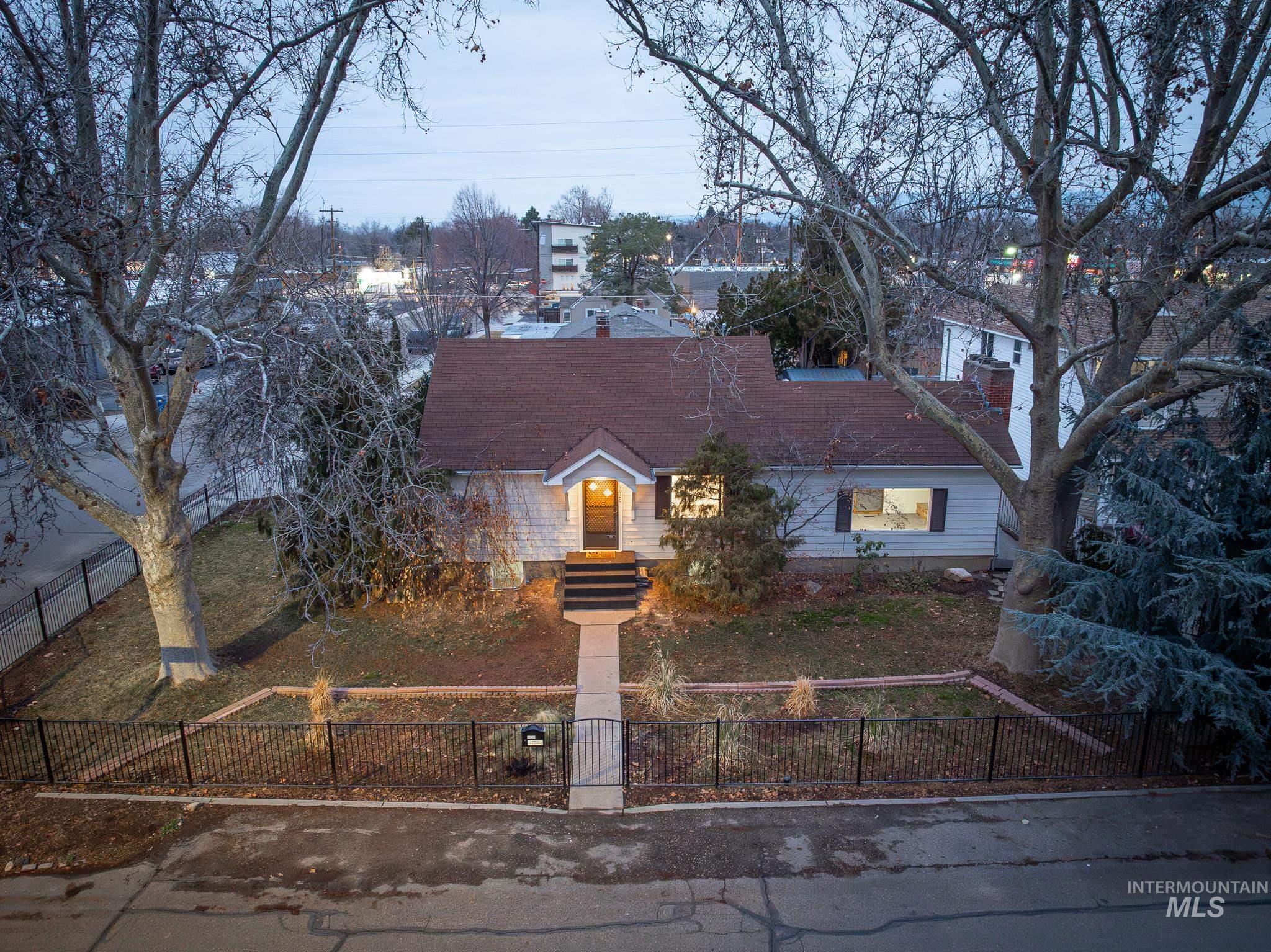 3920 West Dorian Street Boise, ID 83705 - Photo 2 of 4 Cape cod-style house with a fenced front yard and a shingled roof