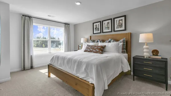 a bed sitting in a bedroom next to a window