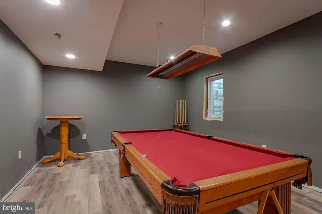 a room with pool table and a wooden floor