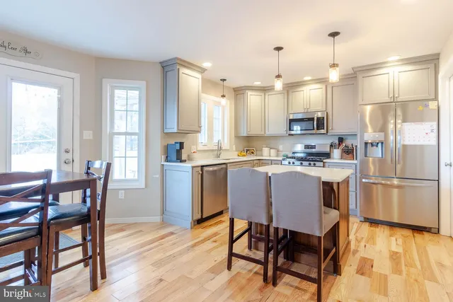 a kitchen with kitchen island a dining table and chairs