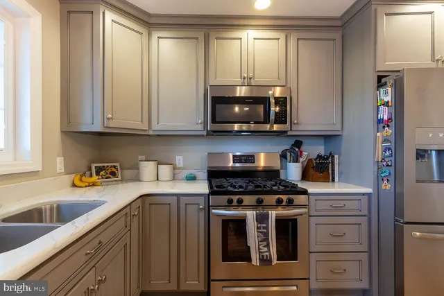 a kitchen with appliances a sink and cabinets