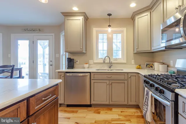 a kitchen with stainless steel appliances granite countertop a sink stove and cabinets