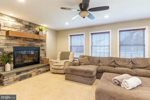 a living room with furniture a fireplace and a large window