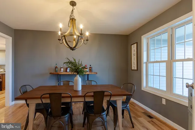 a dining room with furniture a chandelier and window