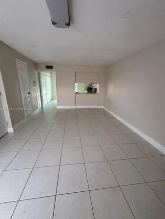 a view of empty room with cabinet and window