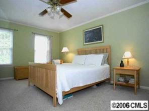 10345 Fairway Ridge Road Charlotte, NC 28277 - Photo 7 of 8 a bedroom with a bed and a chandelier