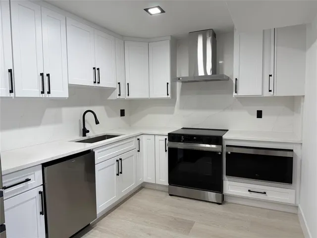 a kitchen with cabinets stainless steel appliances and sink