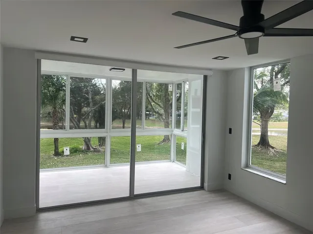 a view of an empty room with wooden floor and a sliding door