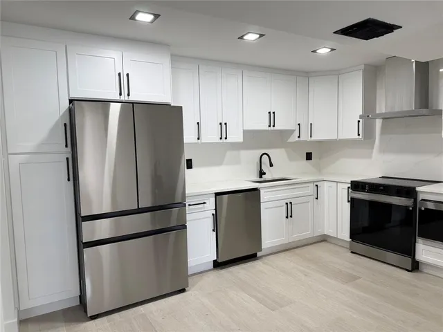 a kitchen with cabinets stainless steel appliances and a counter space