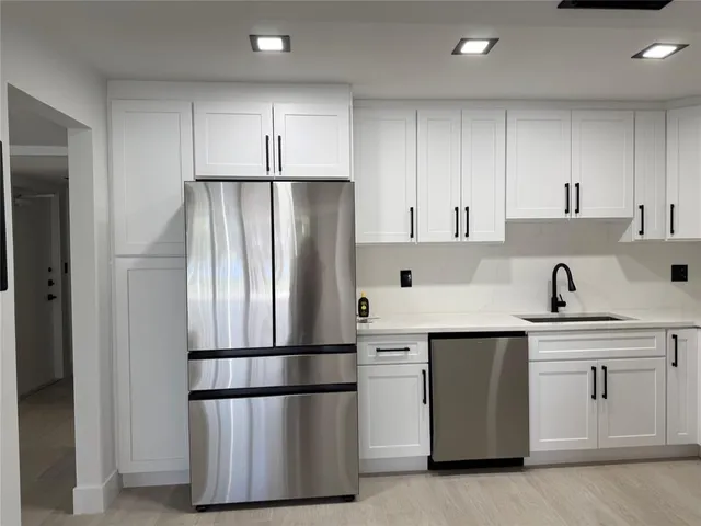 a kitchen with stainless steel appliances a refrigerator sink and cabinets