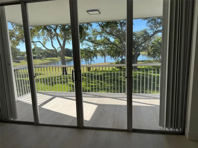 a view of a glass door with a tree from a window