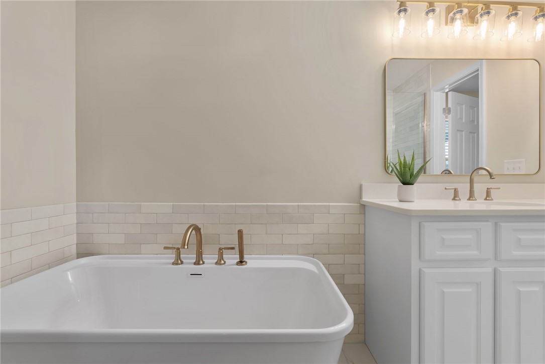 3513 Hopewell Road Anderson, SC 29621 - Photo 17 of 50 Indulge in relaxation with a spacious soaking tub and an elegant vanity featuring a stylish rectangular mirror.