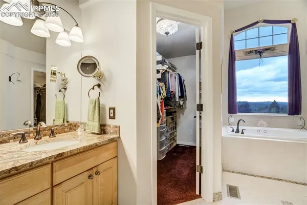 a bathroom with a tub sink and mirror