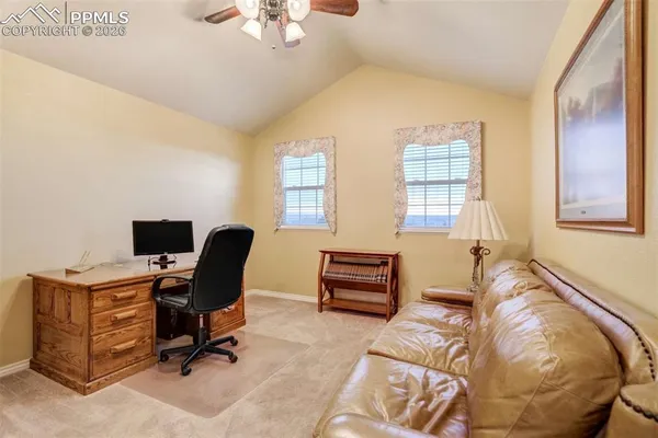 a view of a workspace with furniture and a window
