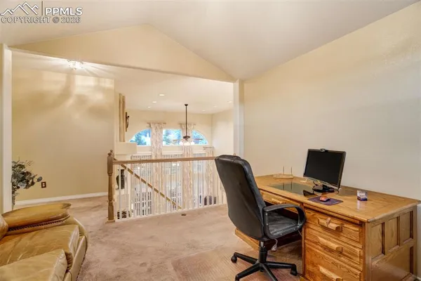 a view of a workspace with furniture and a window