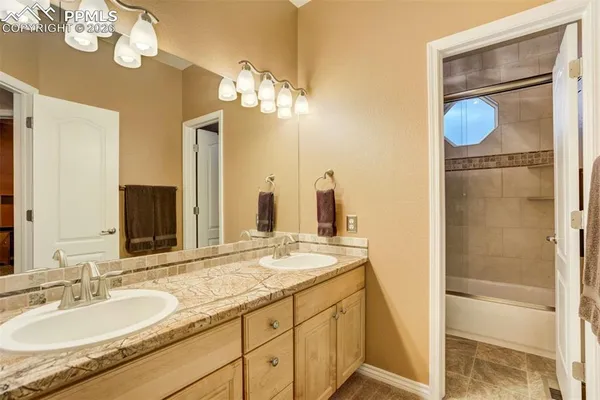 a bathroom with a granite countertop sink a mirror and shower