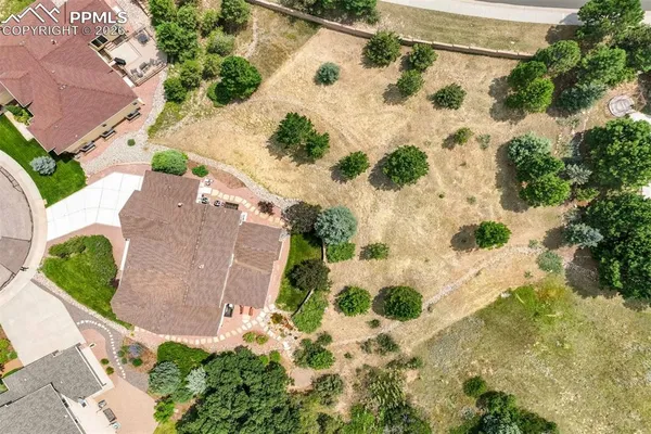 an aerial view of a house with a yard and a large tree