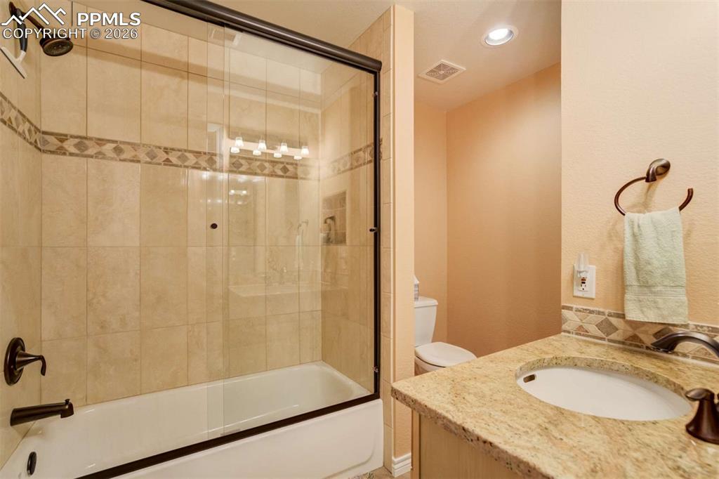 4618 Bethany Court Colorado Springs, CO 80918 - Photo 34 of 50 a bathroom with a granite countertop sink a mirror and shower